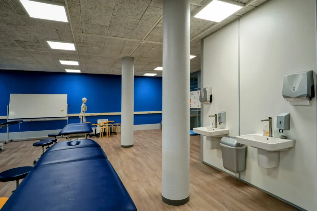 Hygiënische zone in een zorg- en onderwijsinterieur met Duravit No.1 wastafels en Duravit Wave kranen tegen een lichtgrijze RAL 7047 wand, ontworpen door Blossom Interior.