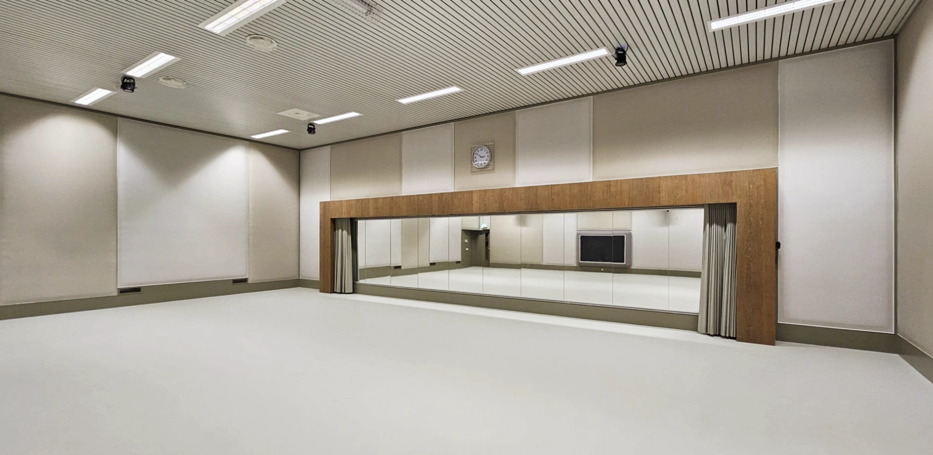 Herinrichting Onderwijsruimte: Getransformeerde LGM-ruimte Zaal 6 op Hogeschool Windesheim – akoestische wandpanelen, gietvloer met vloerverwarming en spiegelkast met Fraké-houten omraming, interieurontwerp Blossom Interior Zwolle